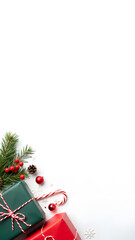 Red, green gift boxes and other Christmas decorations on white backdrop