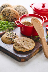 Gourmet Liver Pate Appetizer with Sesame Seed Bagels and and Fresh Pea Shoots on Rustic Wooden Board