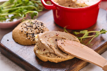 Gourmet Liver Pate Appetizer with Sesame Seed Bagels and and Fresh Pea Shoots on Rustic Wooden Board
