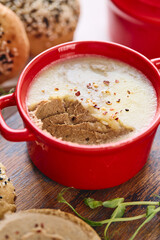 Gourmet Liver Pate Appetizer with Sesame Seed Bagels and and Fresh Pea Shoots on Rustic Wooden Board