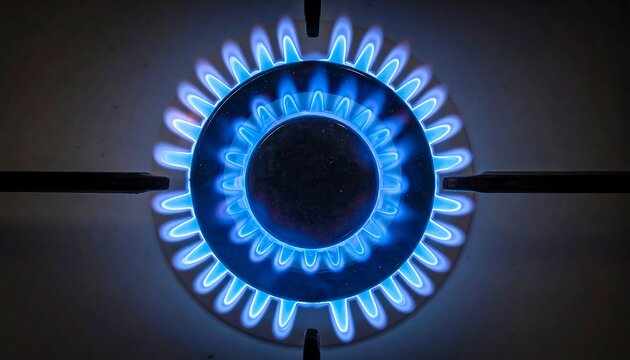 Close-up, top view of a gas burner with bright blue flames emitting from the burner