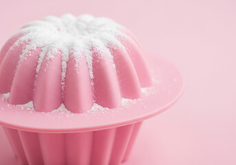 Decorative pink cupcake shaped candle with sweet frosting swirls on a pastel background