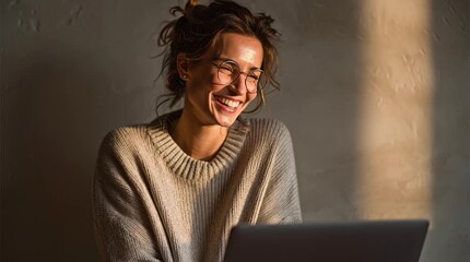 Woman laughing during a video call on laptop, soft warm light. Captures human connection, joy, and engagement, ideal for remote work or digital service advertising.