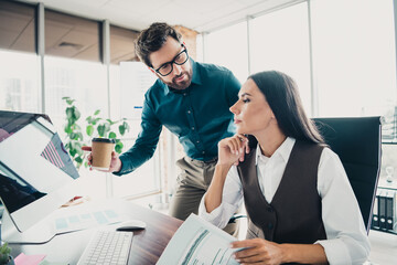 Obraz premium Two colleagues discuss a project at a modern loft office with coffee and documents