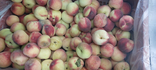 Ripe peaches in a plastic bag on the counter of the store