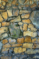wild stone dirty yellow-grey colors wall, abstract natural texture background. fragment of old stone wall made of rough wild cobblestones. template for design