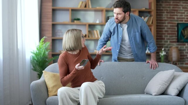 Angry jealous husband suspects his wife of infidelity who uses mobile phone. Quarrel due to jealousy caused by chatting and flirting via social media. Woman has an addiction to smartphone and Internet