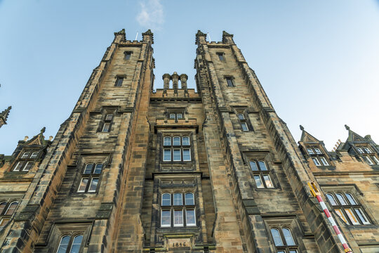 View of the Assembly Hall historic stone building with intricate details reaching towards the soft blue sky, creating a captivating architectural scene, Old town, Edinburgh, Scotland, United Kingdom.