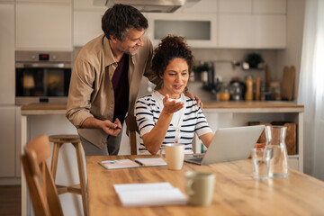 Warm Family Couple In Modern Kitchen Working Together On Laptop At Home