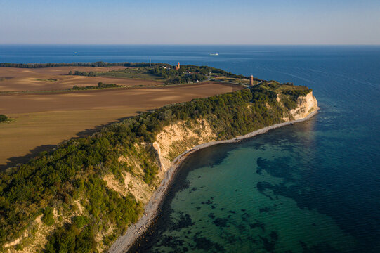 Aerial view of dramatic chalk cliffs fringed with verdant trees meeting the turquoise sea at Cape Arkona, Putgarten, Mecklenburg-Vorpommern, Germany.