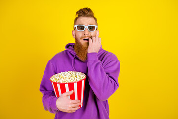 Young man in purple hoodie holds popcorn and wears white glasses against a yellow background in a fun bold promo style