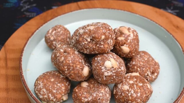 homemade peanut jaggery laddus arranged on a plate. This traditional Indian winter sweet is commonly prepared during cold months to provide warmth and energy. seasonal eating habits and cultural food