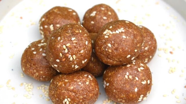 homemade til or sesame seed laddus neatly arranged on a white plate