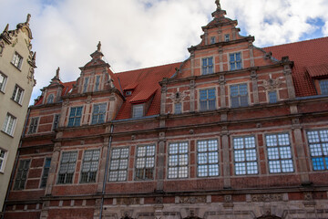 A historic brick building in Gdansk, Poland. The structure features multiple large windows and decorative elements on its facade. Grand entrance of Gdansk Green Gate