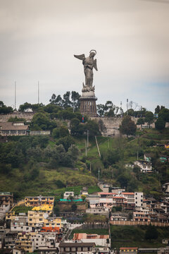 View of the towering Virgin of Quito statue stands majestically atop Panecillo Hill, overlooking the vibrant cityscape below, a blend of modern and historic architecture, Quito, Ecuador.