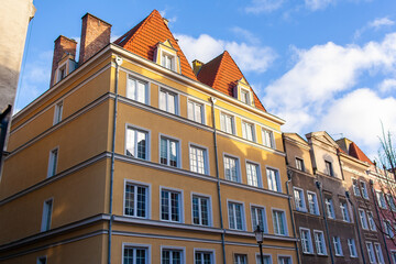 A walk near tall buildings with different colors and styles in a lively urban setting during daylight in Gdansk, Poland