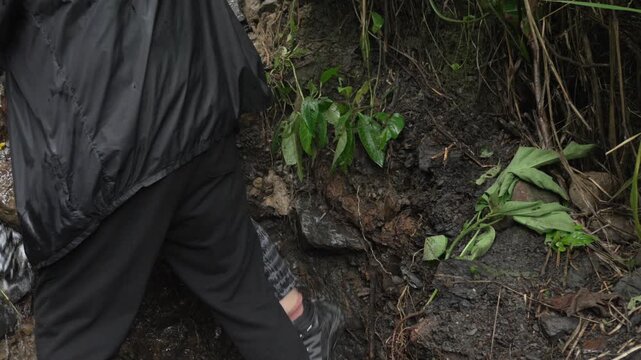 Climbing down downstream river outdoor muddy trek in Salto de las Monjas Colombia