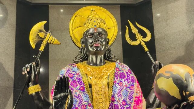 close-up view of Shani Dev&rsquo;s face and upper body, adorned with a golden halo, intricate shawl, and traditional ornaments