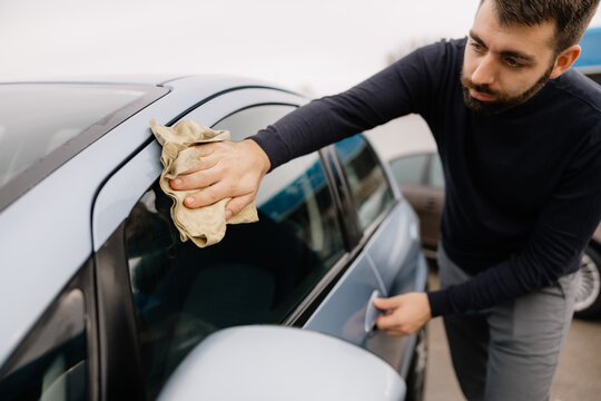 Man working at car wash cleaning vehicle surface