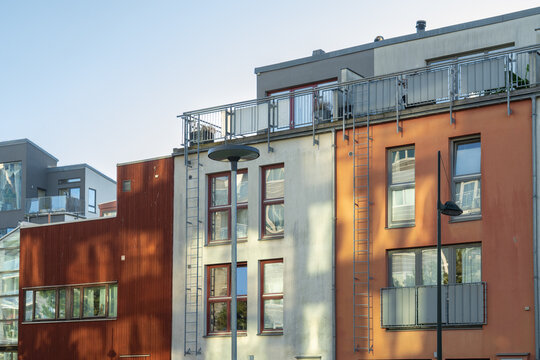 View of the colorful modern architecture featuring vibrant orange and white facades under a clear sky, creating a striking urban scene, Vastra Hamnen, Malmo, Sweden.