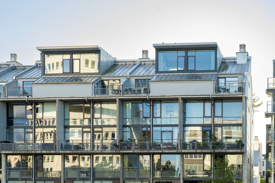 View of modern architecture featuring reflective glass windows mirroring the sky and surrounding buildings under the sunlight, Vastra Hamnen, Malmo, Sweden.