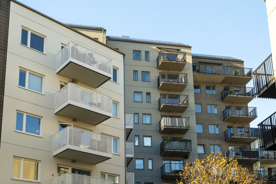 View of modern apartment buildings rise with neutral colors and white balconies against a clear sky, providing a serene urban vista, Vastra Hamnen, Malmo, Sweden.