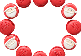 Red Christmas macarons arranged in circular wreath pattern with Santa decorations, isolated on a transparent background