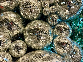 Shimmering disco balls of various sizes, reflecting light in a vibrant arrangement, creating a festive atmosphere for celebrations and events, showcasing dazzling reflections. Christmas background