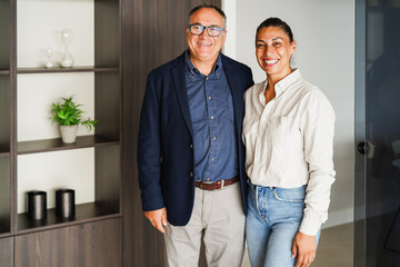 Latin american business agents couple smiling on camera inside real estate agency office -...