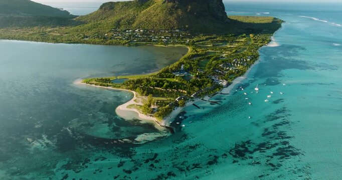 Aerial view of Le Morne Brabant, a peninsula with a large basaltic monolith, surrounded by turquoise water, lush greens, and white sandy beaches, Le Morne, Mauritius.