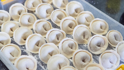 Fresh homemade pelmeni with smooth dough texture, natural shape, and appetizing appearance. Perfect food background for culinary blogs, menus, restaurants.