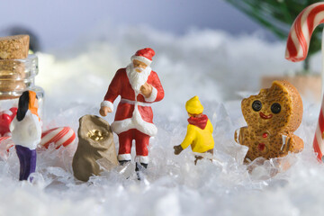 Creative ho scale miniature christmas scenes, santa claus, musicians, and families in a giant candy santa claus delivering christmas gifts in a miniature winter wonderland