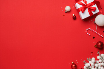 Red and white Christmas decorations and gifts on red background.