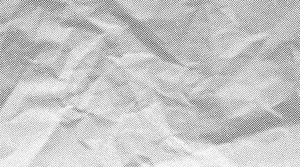 Halftone crumpled paper texture with black a dotted, rough, and wrinkled surface. Wite creased sheet background in comic pop-art style, featuring grainy folds and gritty distressed details. © Maryna
