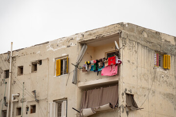 Colorful laundry hanging from an upstairs balcony of a run down apartment building at the Catacombs of Kos el Shoqafa in Alexandria, Egypt
