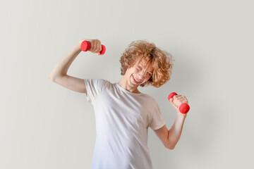 Teen Boy Exercising With Dumbbells At Home In Casual Style. Concept Of Youth Fitness, Gen Z Wellness, Active Lifestyle, Healthy Routines, And Modern Campaigns On Mental And Physical Health
