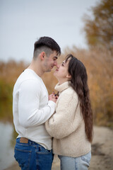 Fototapeta premium A happy young couple is walking on the river bank