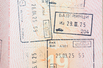 Macro view of passport paper filled with immigration stamps and official markings. Symbolizes legal...