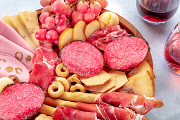 Italian Antipasti close-up. Charcuterie platter with prosciutto, salami, Bologna ham, cheese and fruit