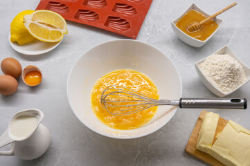 Ingredients for preparing Madeleine cookies. The dough preparation process. Top view.