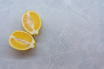 two halves of fresh lemon on a gray background.