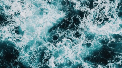 Fototapeta premium Turbulent ocean waves create a mesmerizing pattern of frothy white and deep blue, illustrating the beauty and power of nature.
