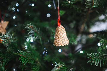 Natural material Christmas bell ornament hanging on tree, rustic festive decoration detail