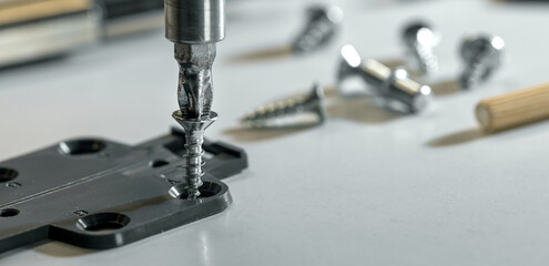 Furniture assembly. Closeup of screwing a screw in MDF material
