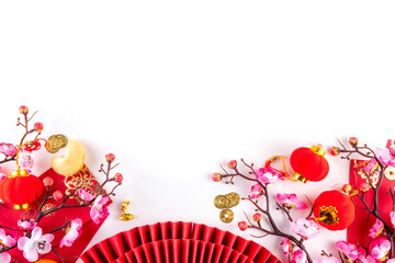 Bright vibrant gold and red Chinese New Year background with mandarin oranges, blossom tree branches, decorative fans, festive greeting envelops and coins, traditional Chinese New Year ornaments