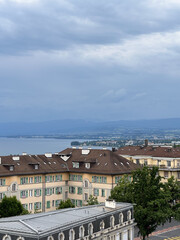 Overcast View of a European City by a Lake with Distant Mountains