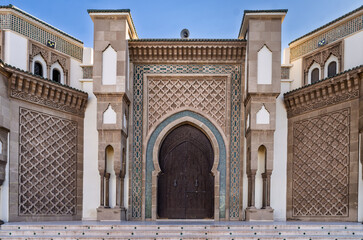 Moroccan Mosque Exterior With Tall Minaret And Ornate Entrance Under Blue Sky, Agadir
