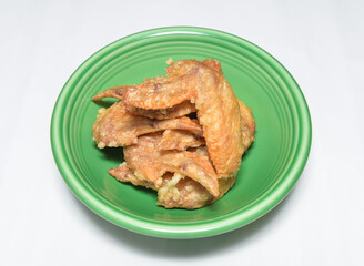 Crispy golden fried chicken wings piled high in a vibrant green bowl ready for a delicious appetizer
