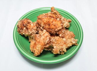 Crispy fried chicken pieces on a green plate