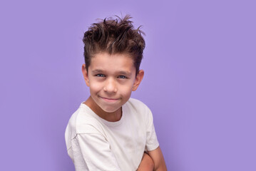 Bright, friendly portrait of a smiling happy boy in a white shirt against a purple background. Perfect for family, kids, education, and lifestyle theme